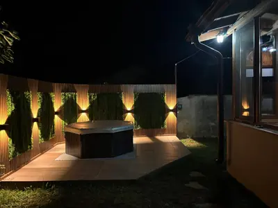 a lit up patio at night with a bench and lights at Вила НАДЕЖДА in Byala