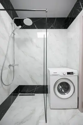 a washing machine in a bathroom with a shower at Azur Properties ap50 in Shkorpilovtsi