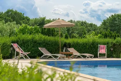 a group of chairs and an umbrella next to a pool at Azur Properties ap51 in Shkorpilovtsi