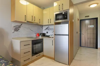 a kitchen with yellow cabinets and a white refrigerator at Azur Properties ap51 in Shkorpilovtsi