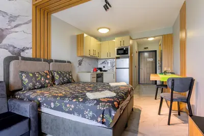 a small room with a bed and a kitchen at Azur Properties ap51 in Shkorpilovtsi