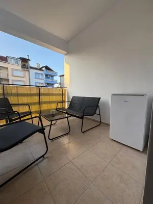 a balcony with chairs and a whiteboard on a building at Studio by the sea in Primorsko