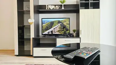 a living room with a tv in a entertainment center at Апартамент Комфорт in Varna City