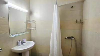 a bathroom with a sink and a shower with a shower curtain at Апартамент Комфорт in Varna City