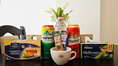 a table with cans of drinks and a cup of coffee at Апартамент Комфорт in Varna City