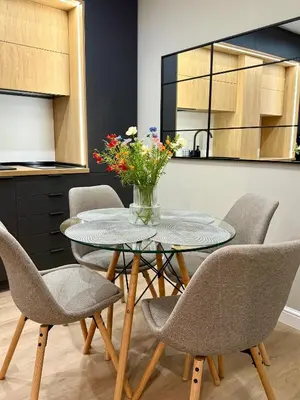 a dining room table with chairs and a vase of flowers at Апартамент Vista Al Mar in Pomorie