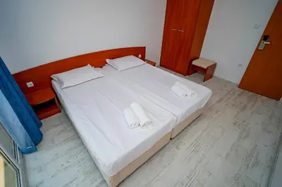 a bedroom with a bed with white sheets and towels at Next to Harmanite Beach - 1 BD Flat with Own Parking spot by Flat Mаnager in Sozopol