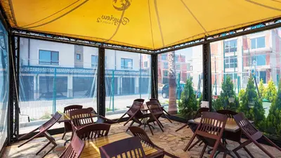 a restaurant with tables and chairs and a yellow tent at Sea Holiday 21 in Burgas City