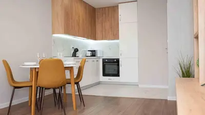 a kitchen with a table and chairs in a room at Sea Holiday 21 in Burgas City