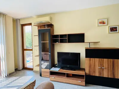 a living room with a flat screen tv and a entertainment center at KALIA C9 One Bedroom Apartment in Sunny Beach