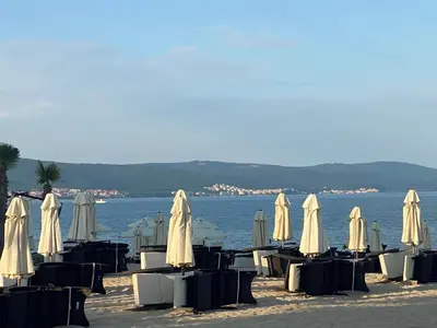 a group of tables and chairs with umbrellas on the beach at KALIA C9 One Bedroom Apartment in Sunny Beach