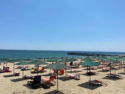 a beach with chairs and umbrellas and the ocean at ASTORIA II Apartment 54 One Bedroom in Elenite