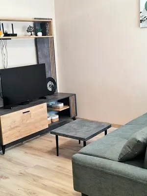 a living room with a flat screen tv and a couch at Fresh & Cozy Flat Near Varna Cathedral in Varna City