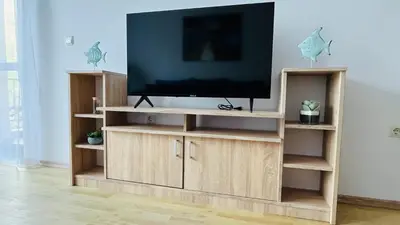 a television on a wooden entertainment center in a living room at ASTORIA II Apartment 23 One Bedroom in Elenite