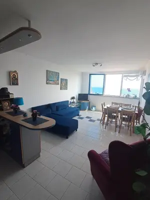 a living room with a blue couch and a table at Yacht Port apartment #sea view# in Sveti Vlas