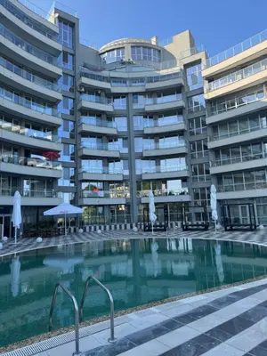 a swimming pool in front of some apartment buildings at Allure by the Sea in Primorsko