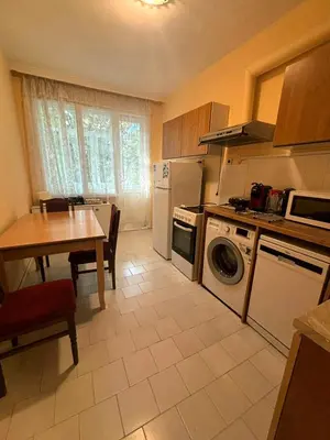 a kitchen with a table and a table and a dining room at Апартамент за гости Весела in Burgas City