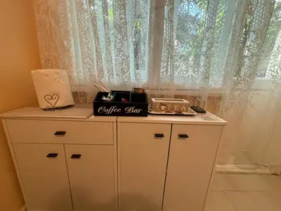 a white cabinet with a counter top with a window at Апартамент за гости Весела in Burgas City