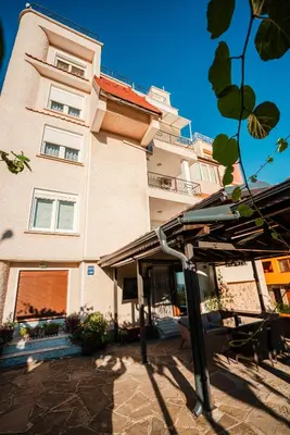 a building with an umbrella in front of a building at Apartment Lotus in Sveti Vlas
