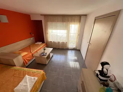 a bedroom with orange walls and a bed and a window at Apartment Lotus in Sveti Vlas