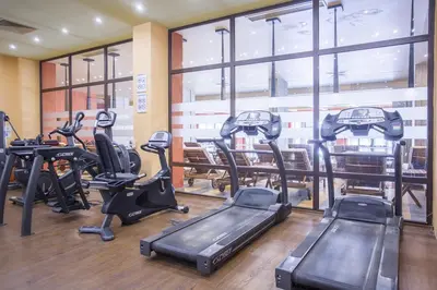 a gym with treadmills and ellipticals in front of a window at Royal Barcelo G404 Sunny Beach in Sunny Beach