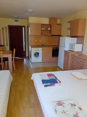 a room with a kitchen with a table and a refrigerator at Студио във Виго Панорама Несебър in Nesebar