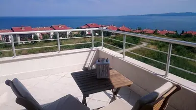 a balcony with a table and chairs and the ocean at High in the Sky Apartments in Sozopol