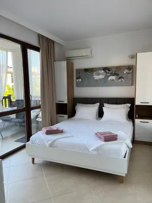 a bedroom with a white bed and a balcony at Двуспален апартамент Оазис Бийч Клуб in Lozenets