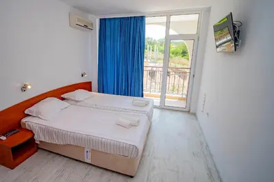 a bedroom with a bed and a large window at Harmani Haven 1BD Apartment with Own Parking spot by Flat Manаger in Sozopol