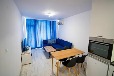 a living room with a blue couch and a table at Harmani Haven 1BD Apartment with Own Parking spot by Flat Manаger in Sozopol