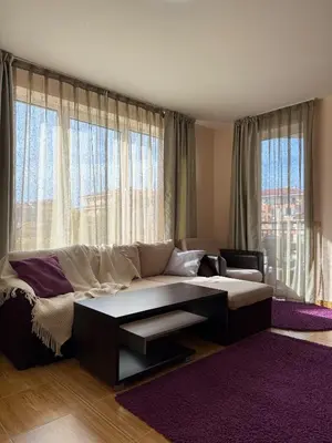 a living room with a couch and a large window at Sky dreams Sveti Vlas in Sveti Vlas