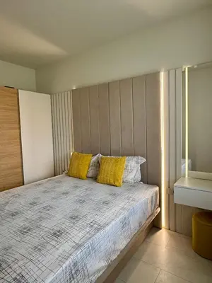 a bedroom with a bed with two yellow pillows at Domenico Luxury Apartments in Sunny Beach