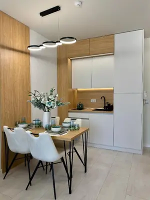 a kitchen with a wooden table and white chairs at Domenico Luxury Apartments in Sunny Beach