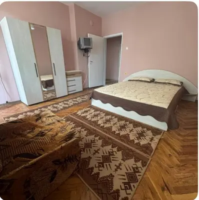 a bedroom with a bed and a large rug at Anastasiya's Flat in Pomorie