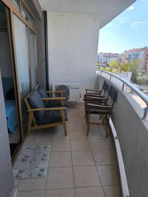 a balcony with chairs and a heater on a building at Апартамент Кара миа in Sveti Vlas