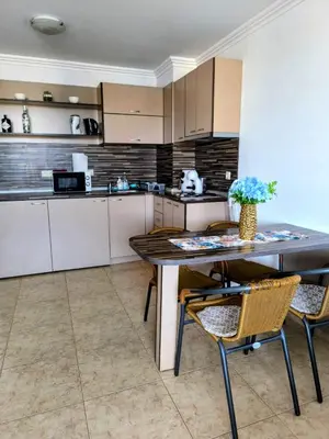 a kitchen with a table and chairs in a room at Апартамент Кара миа in Sveti Vlas