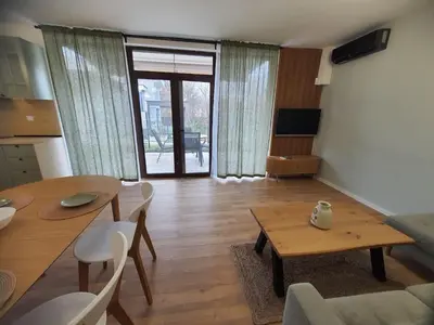 a living room with a table and a dining room at Вила Фамилия - Villa Family in Lozenets