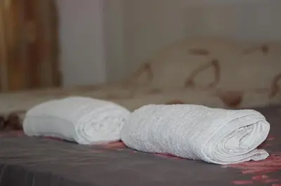 a roll of white towels sitting on a table at Tangra Guest House in Arapya