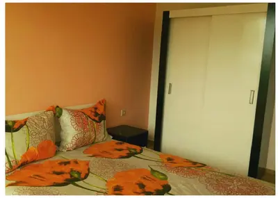 a bedroom with a bed with orange flowers on it at Tangra Guest House in Arapya