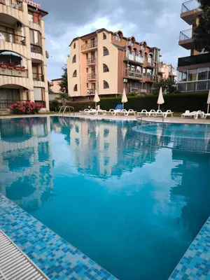 a large swimming pool in front of some buildings at Светлая квартира на 4 этаже in Ravda