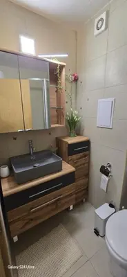 a bathroom with a sink and a mirror and a toilet at Sunny Beach Blue Perl in Sunny Beach