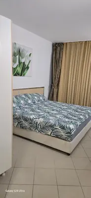 a bed in a room with a blue and white comforter at Sunny Beach Blue Perl in Sunny Beach