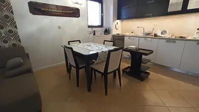 a kitchen with a table and chairs in a room at Premium Oasis Beach Club Apartment in Lozenets
