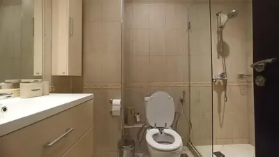 a bathroom with a toilet and a glass shower at Premium Oasis Beach Club Apartment in Lozenets
