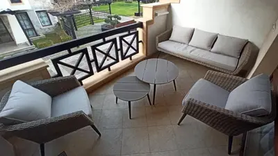 a balcony with a couch and chairs and a table at Premium Oasis Beach Club Apartment in Lozenets