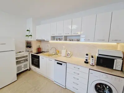 a kitchen with white cabinets and a sink and a dishwasher at Diamond beach apartment in Sveti Vlas