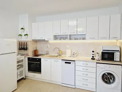 a white kitchen with a sink and a dishwasher at Diamond beach apartment in Sveti Vlas
