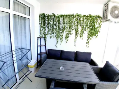 a patio with a couch and a table on a balcony at Lazur 2 beach apartment in Sveti Vlas