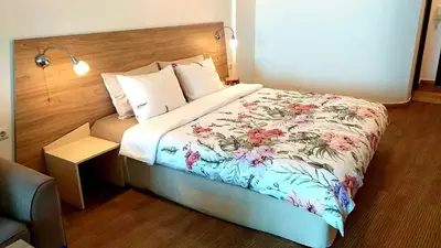 a hotel room with a bed with a floral bedspread at Studio Alma in Byala