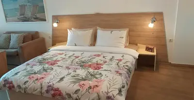 a bedroom with a large bed with a floral bedspread at Studio Alma in Byala